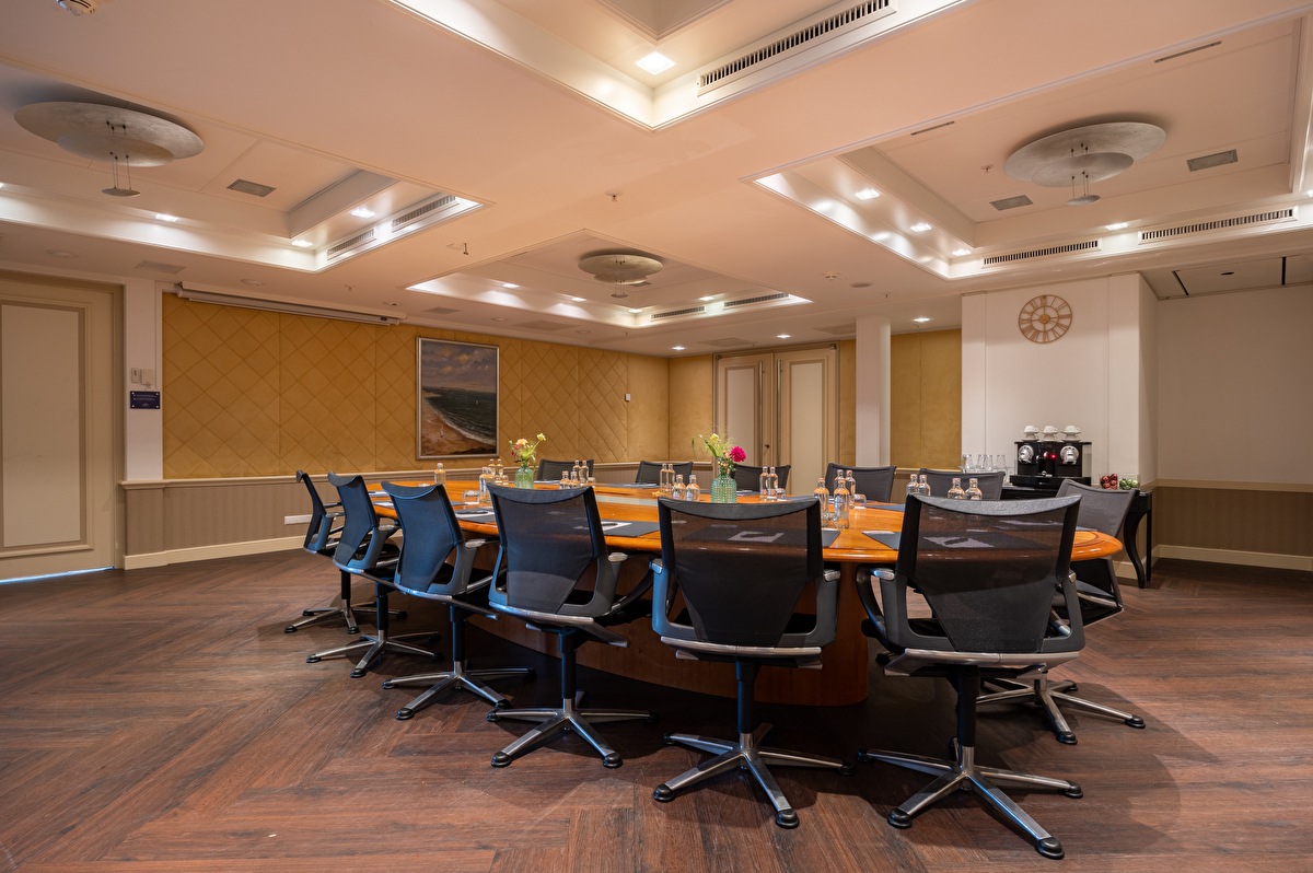 Jacob Maris meeting room in Grand Hotel Amrâth Kurhaus, an oval meeting table with black chairs around it.