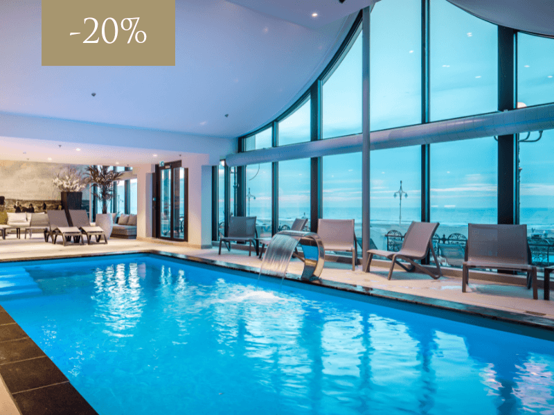 Wellness swimming pool with loungers along the edge and view of the North Sea